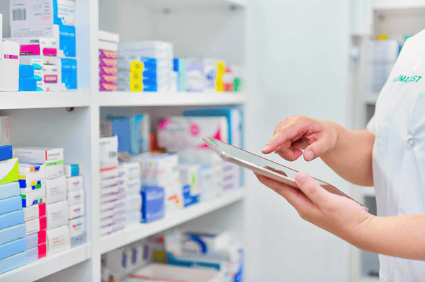 Pharmacienne qui cherche un médicament via une tablette tactile